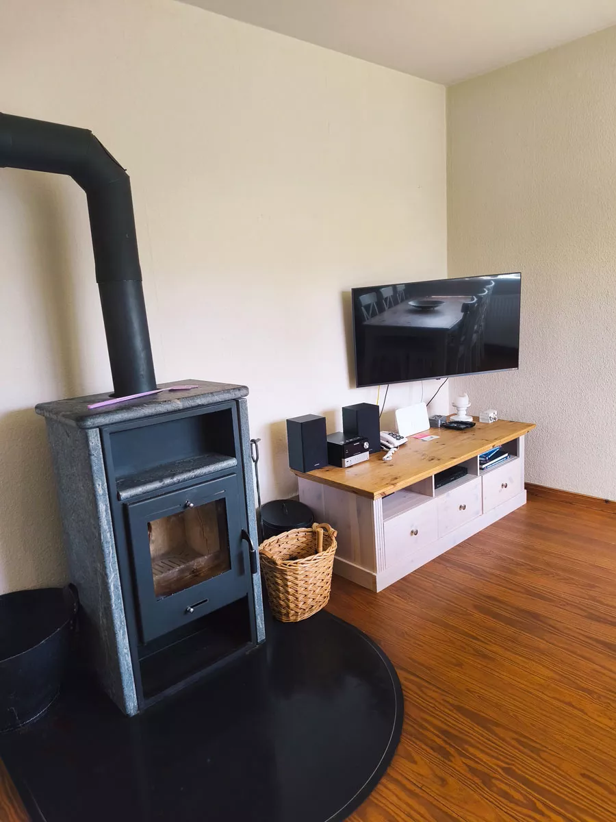 Ferienhaus Deichsonne – Wohnzimmer mit Kaminofen und Fernsehecke Ferienhaus Deichsonne – Wohnzimmer mit Kaminofen und Fernsehecke
