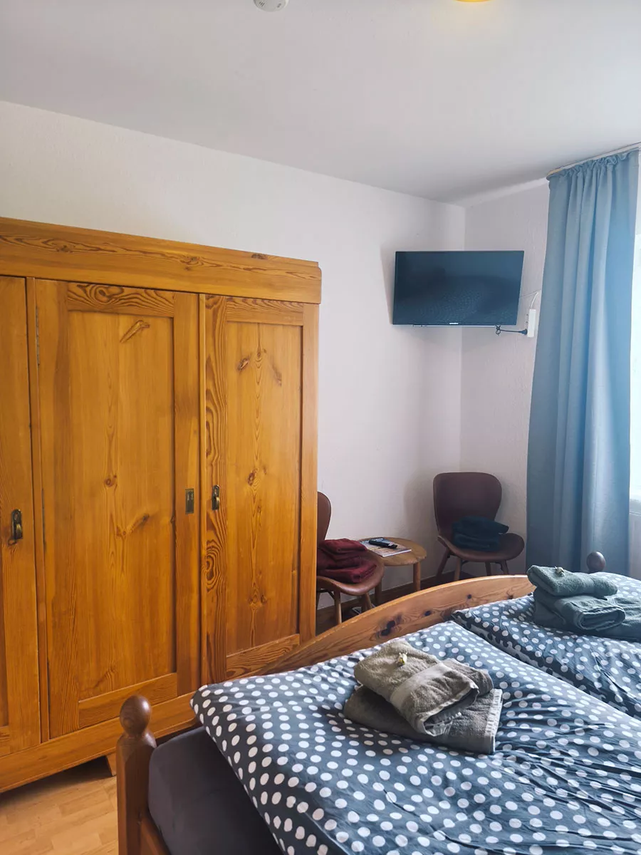 Ferienhaus Deichsonne – Schlafzimmer mit Kleiderschrank, Sitzecke und TV Ferienhaus Deichsonne – Schlafzimmer mit Kleiderschrank, Sitzecke und TV