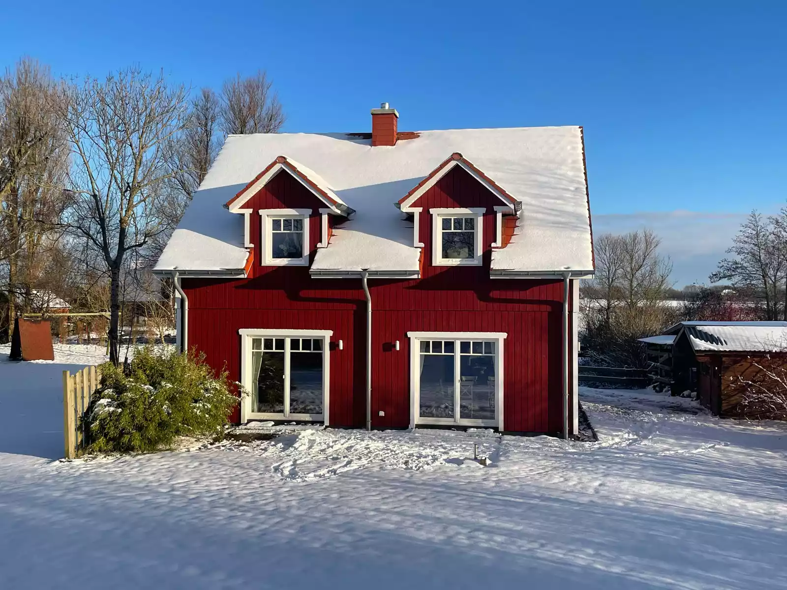 Ferienhaus Deichstern – winterliche Rückseite mit Terrasse und großen Fenstern, Familienurlaub & Paarurlaub